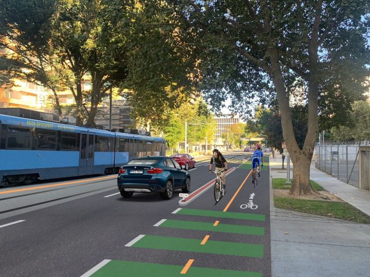 Rendering of two-way bike lane. Two bikes going opposite directions on green bike path. Street, cars, trees, public transit