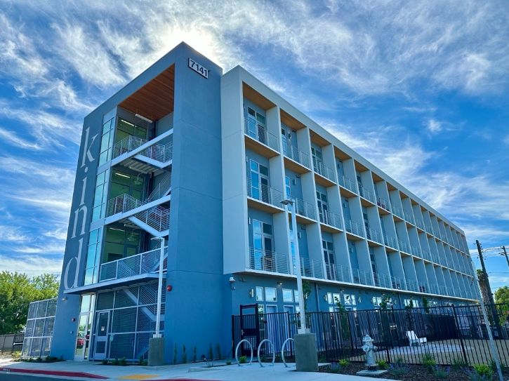 Apartments, text painted on the side of building "kind"