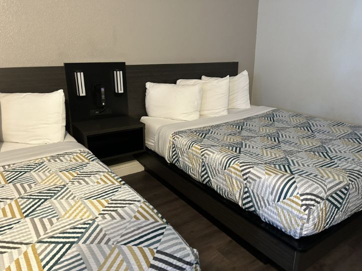 Inside room with two beds. Blanket and pillows. 