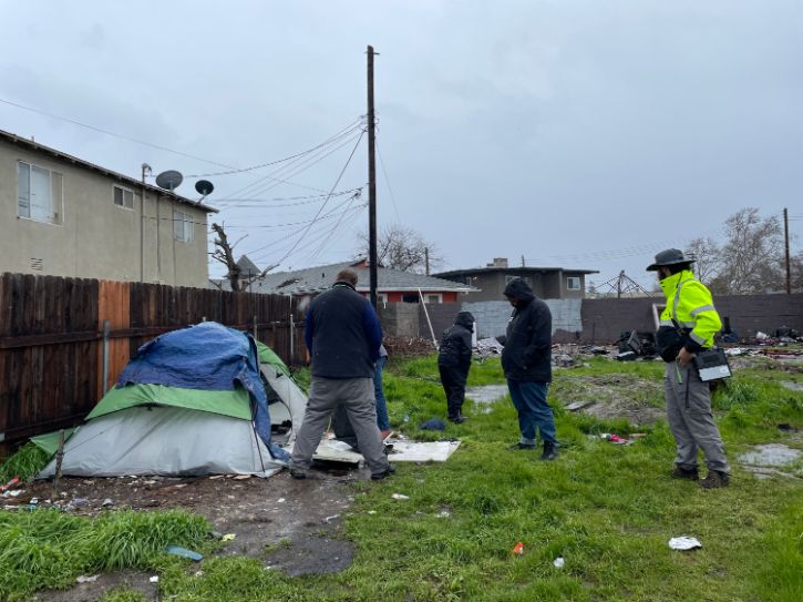 Homeless encampment in field next to homes, City staff