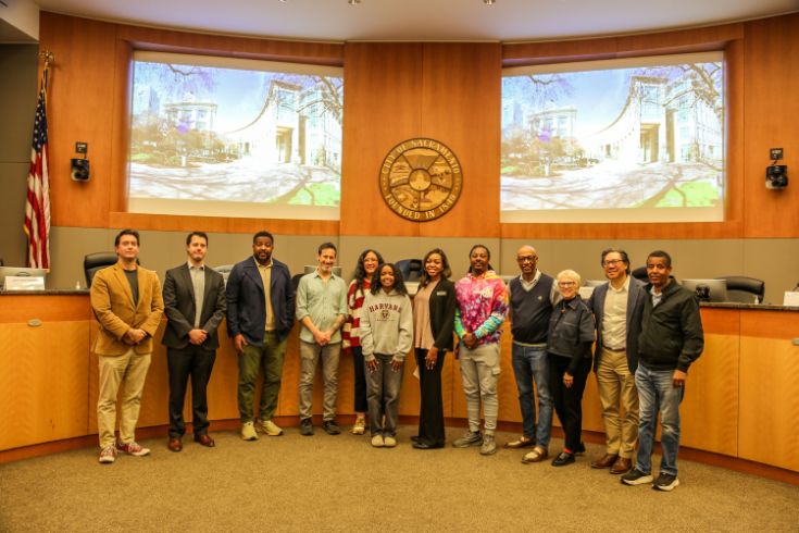 Group photo in Sacramento Council Chambers with young poet in the center.