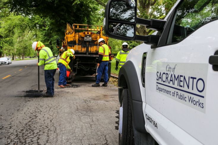 Public Workers repairing potholes in stret. 