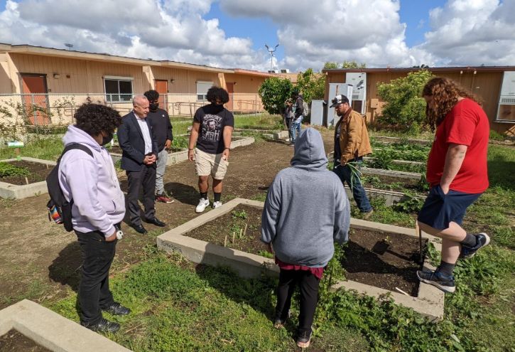 Teens and Mayor in community garden for Thousand Strong program
