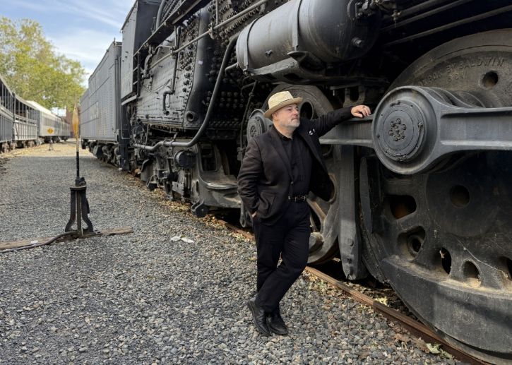 New City Historian, Ty Smith leaning on historic train.