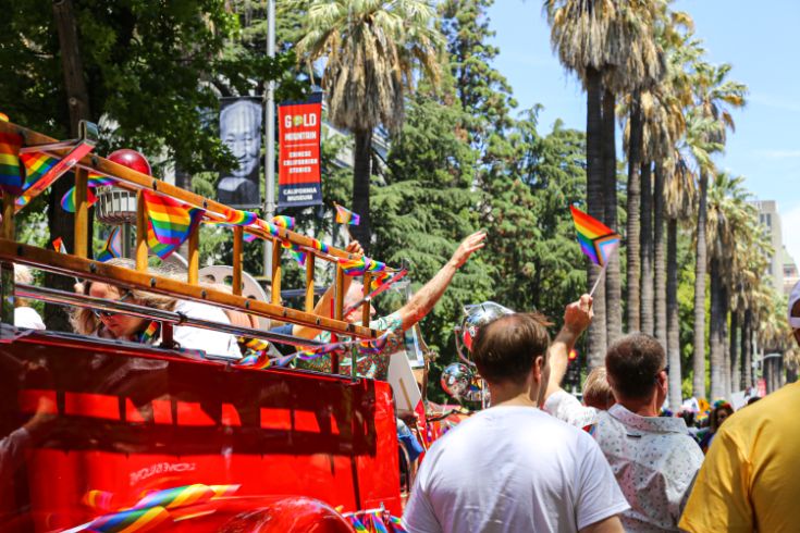 Pride parade, firetruck, rainbow flags, palm trees