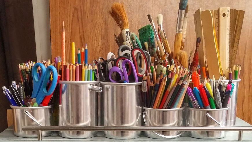 Colorful art supplies in tin cans