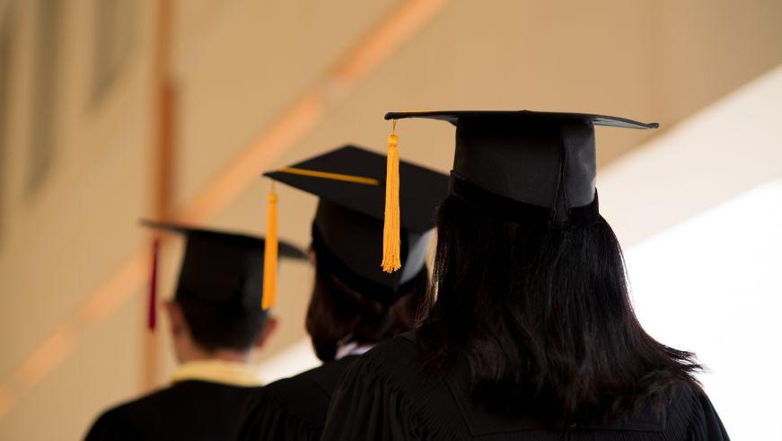 Three people wearing graduation caps