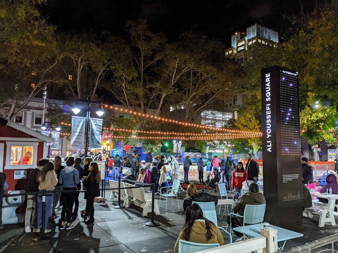 Night life, large crowd, string lights, trees