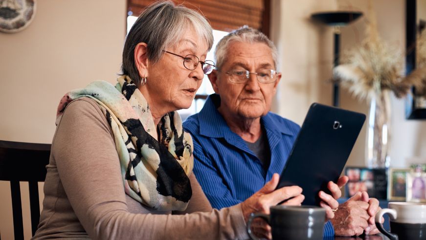 Two seniors using a tablet