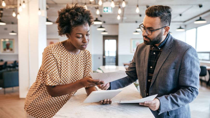 Two people having a business meeting, holding papers