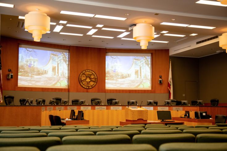 Sacramento Council Chambers. Dias, chairs, podium.