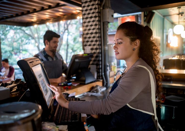 Person at cash register at bar counter.