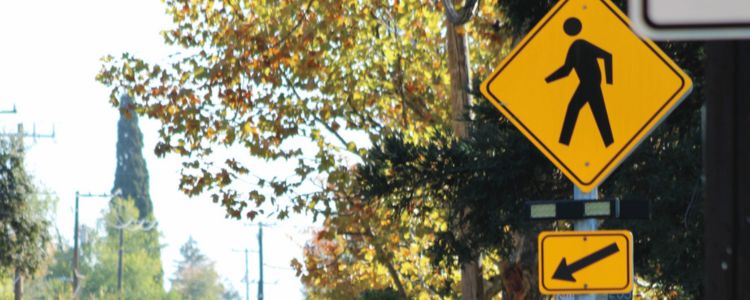 Crosswalk sign and beacon on city street