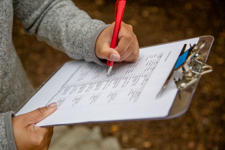 person holding clipboard and pen