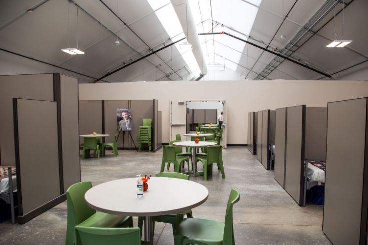 inside X Street Navigation Center. Tables, green chairs, beds