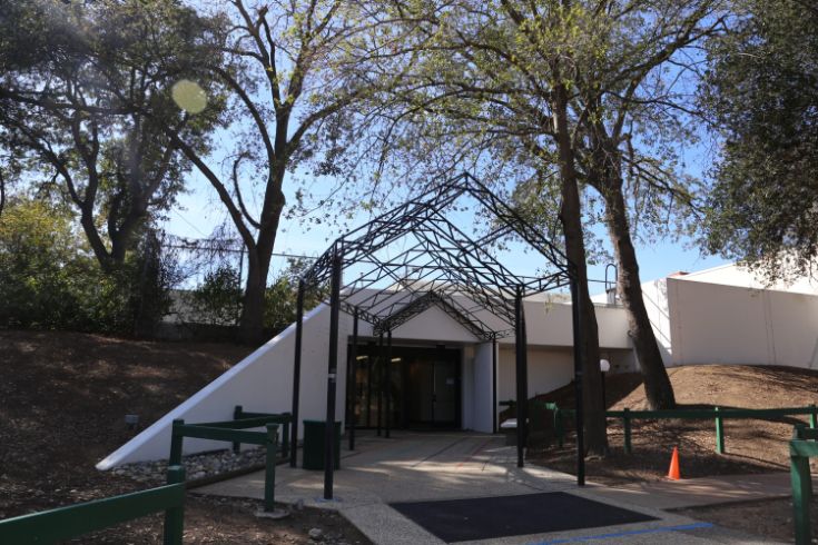 White building, trees, benches, walkway