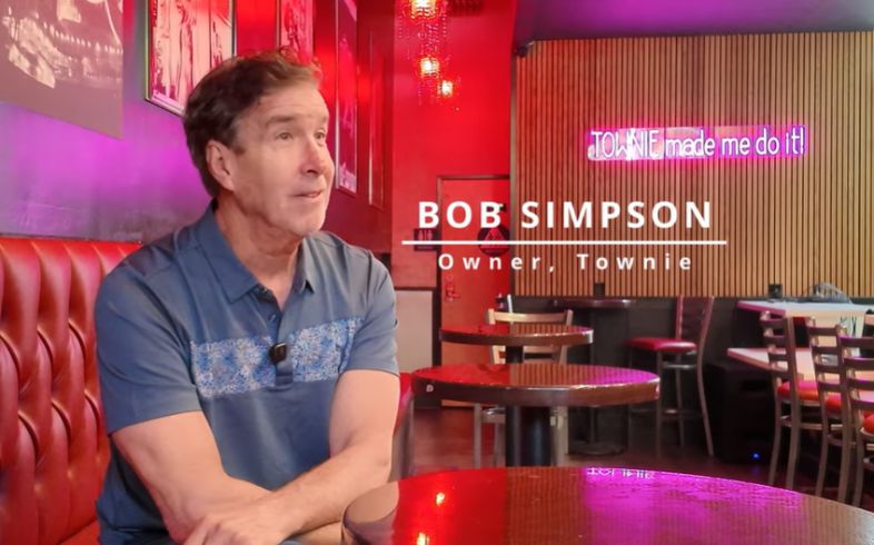 Bob Simpson sitting at table being interviewed