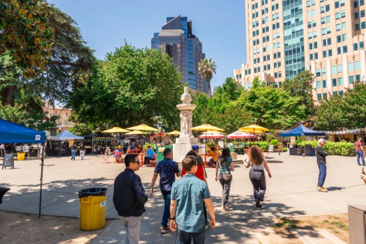 Union square, outdoors, crowds of people, buildings, umbrella, fountain
