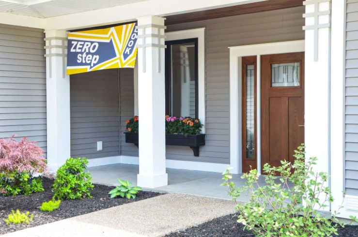 Front porch of house. Brown door, white beams, garden