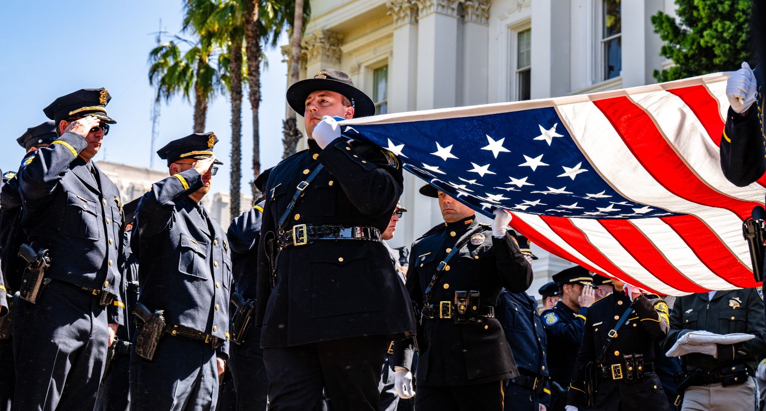 Photo of officers at the California Police Officer Memorial with the American flag