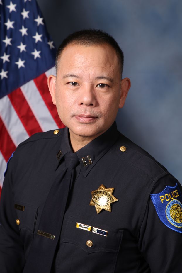 Photo of Captain Rudy Chan in uniform with the American flag in the background
