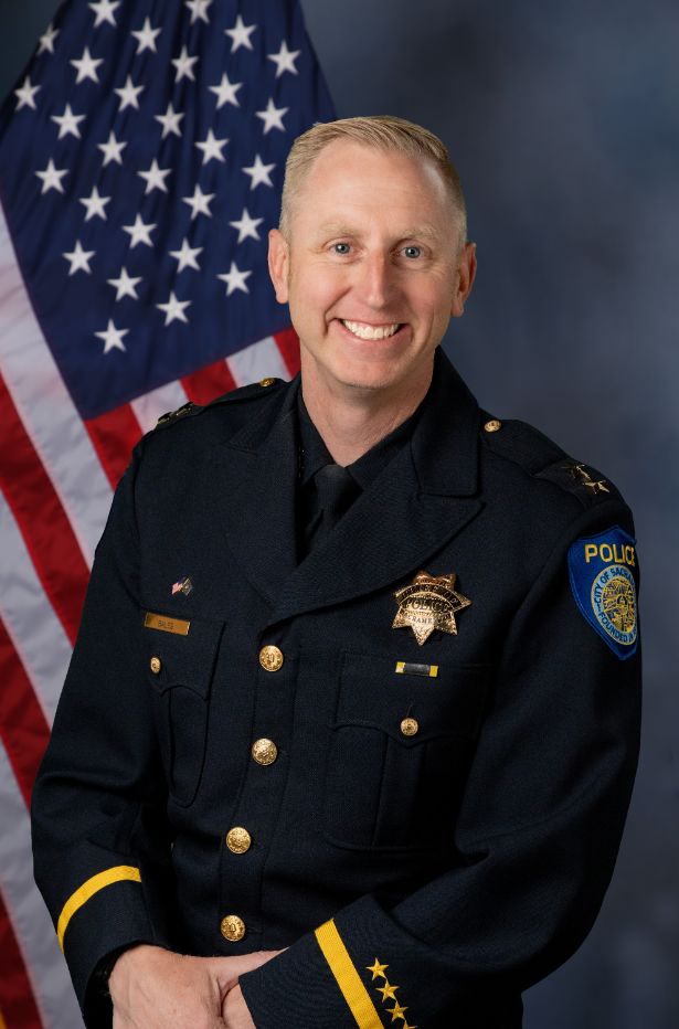 Photo of Zack Bales in uniform with the American flag in the background