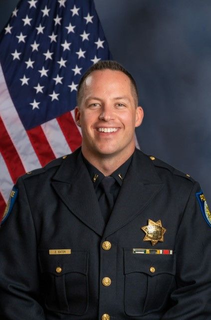 Photo of Zachary Eaton in uniform standing in front of the American flag.