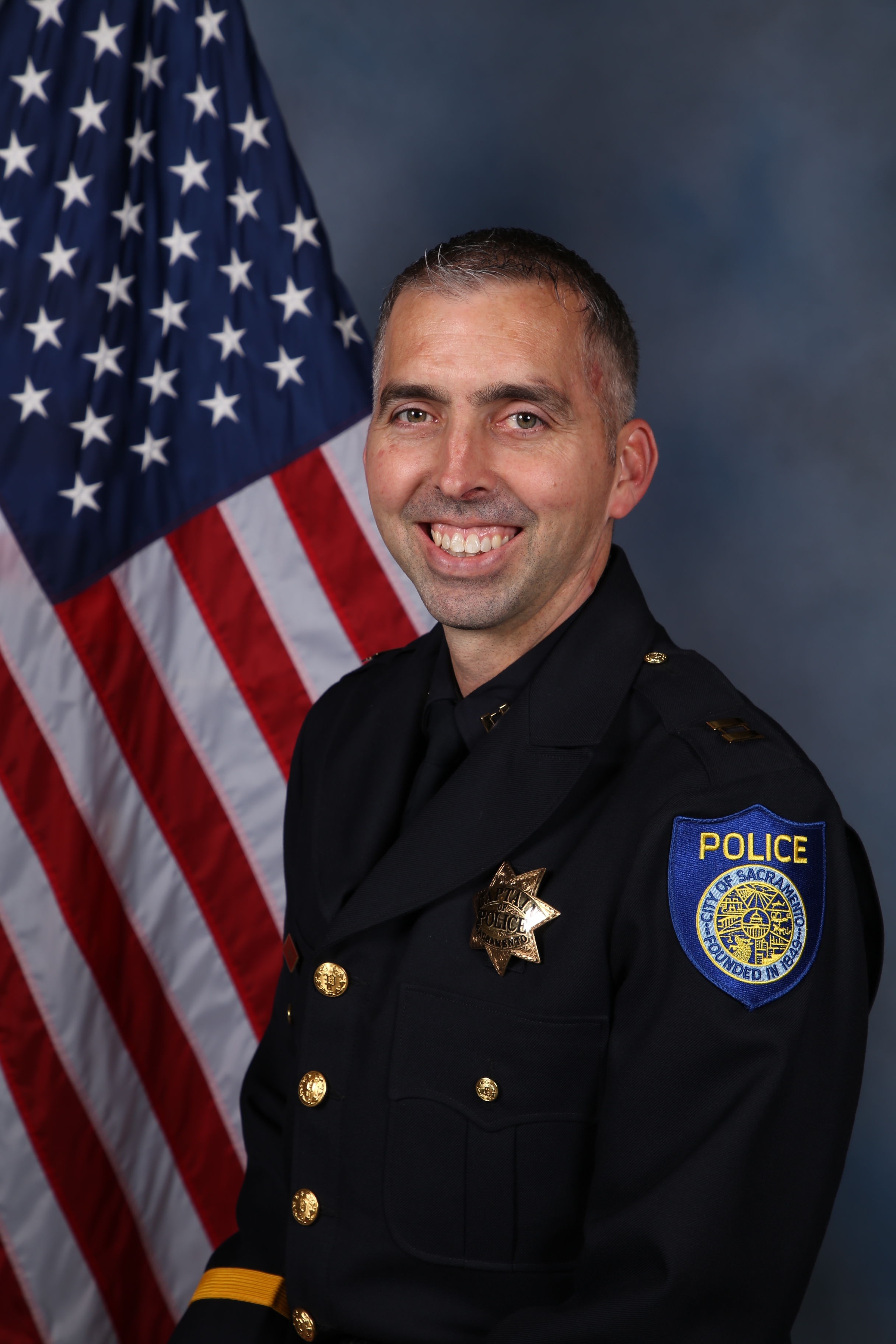 Photo of Captain Ethan Hanson in uniform in front of the American flag