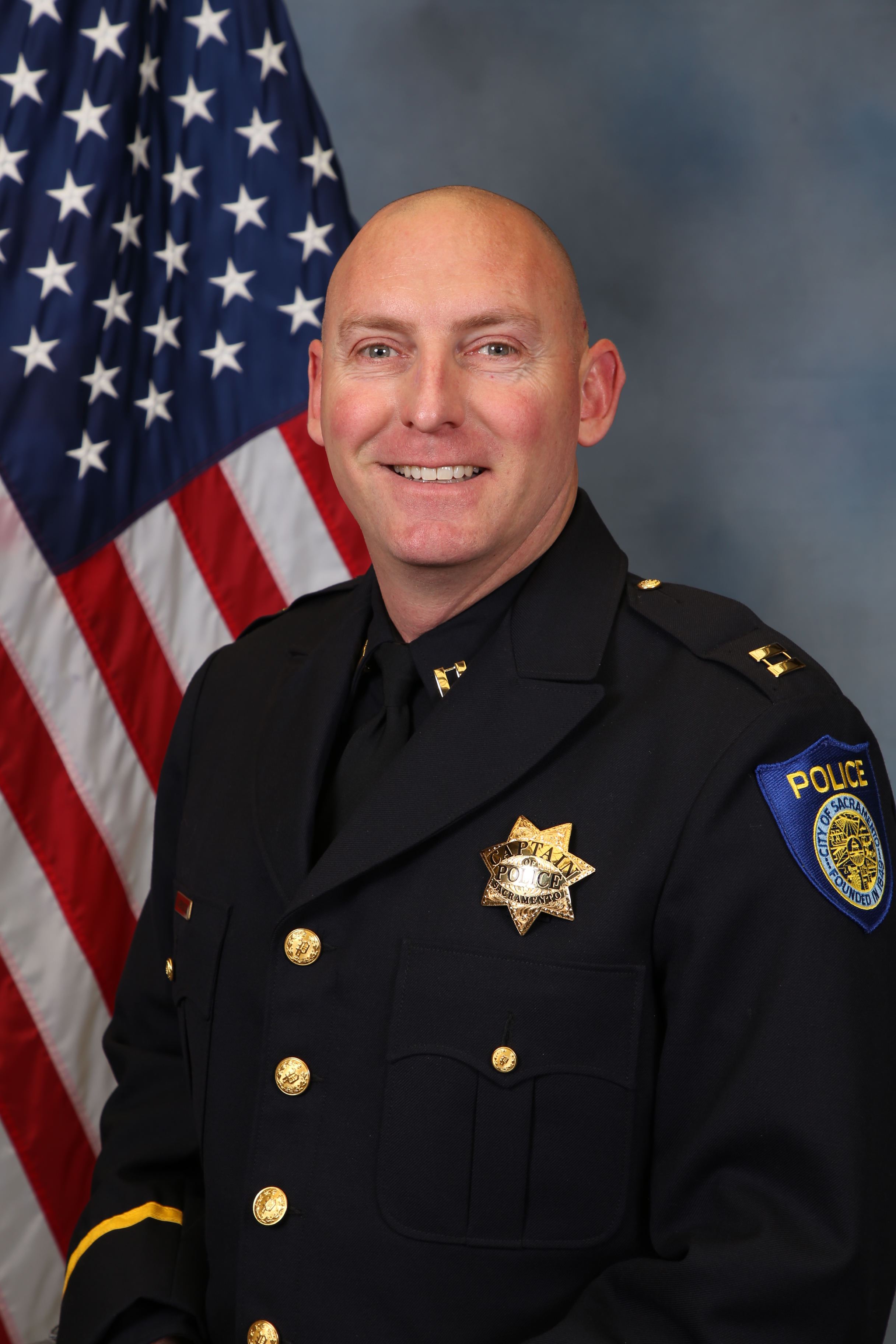 Photo of Captain James Harrington in uniform with the American flag in the background