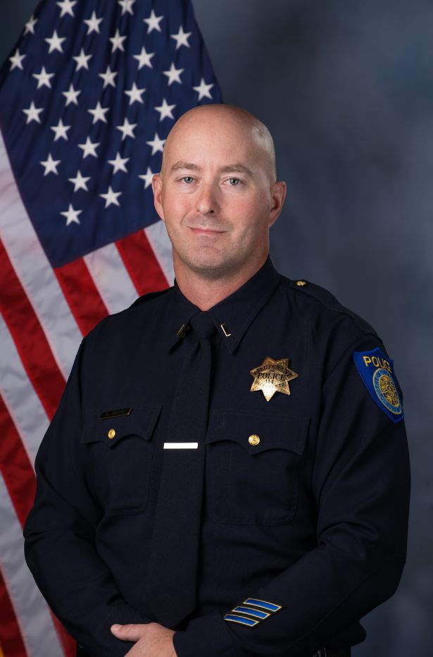 Photo of Robert Young in uniform standing in front of the American flag.