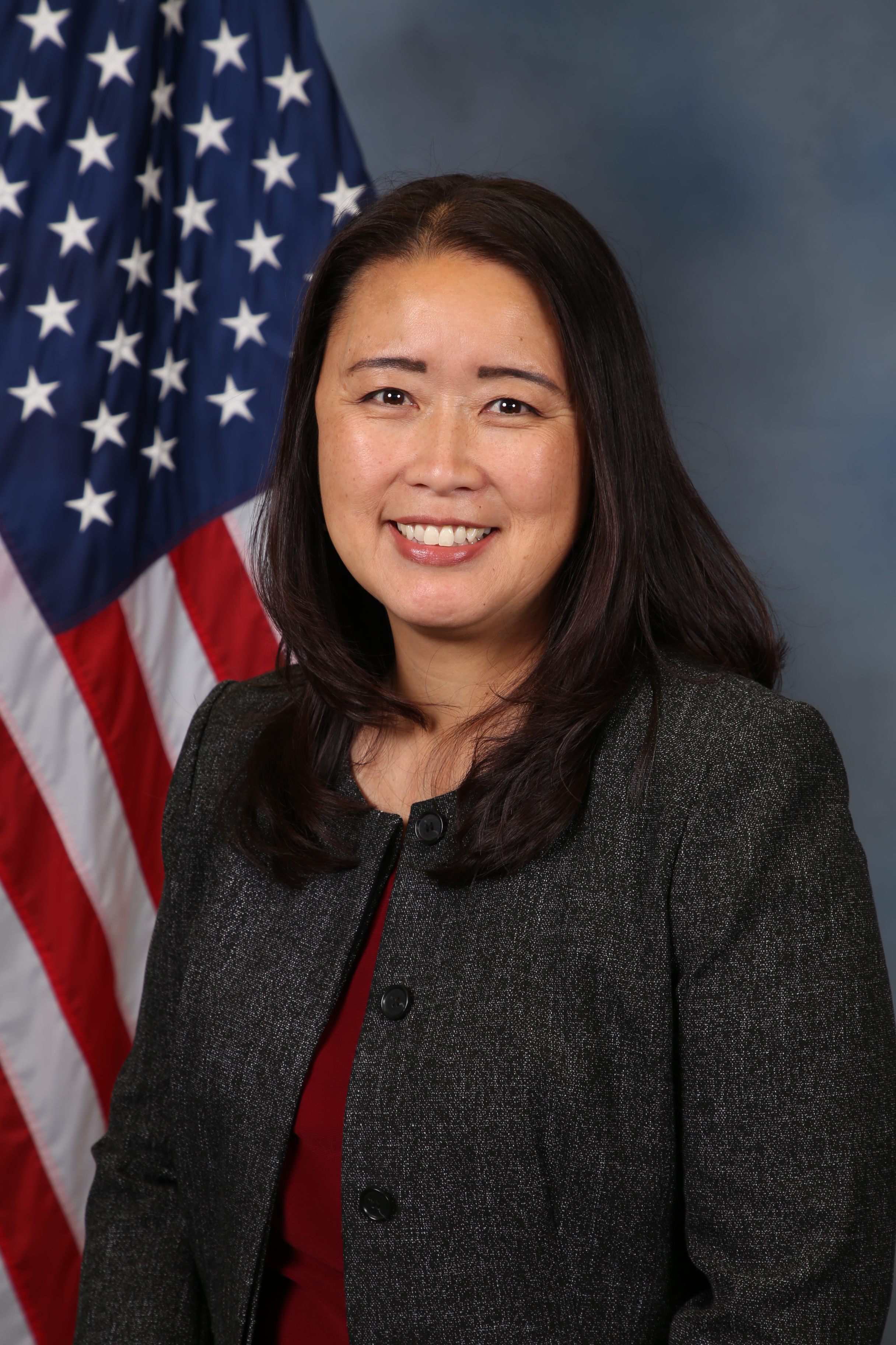 Photo of Audrey Lee in front of the American flag.