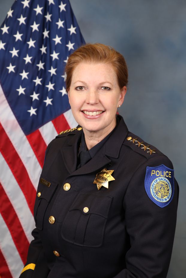 Photo of Chief of Police Kathy Lester in uniform in front of the American flag.