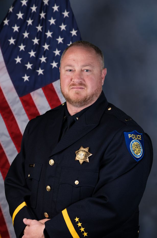 Photo of Dave Putman in uniform standing in front of the American flag.