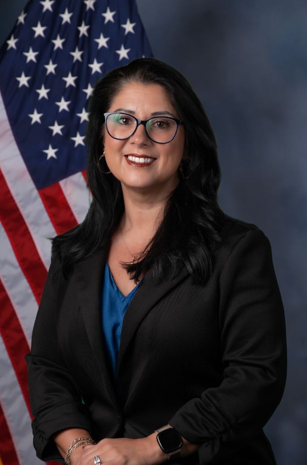 Photo of Tammy Hall standing in front of the American flag.