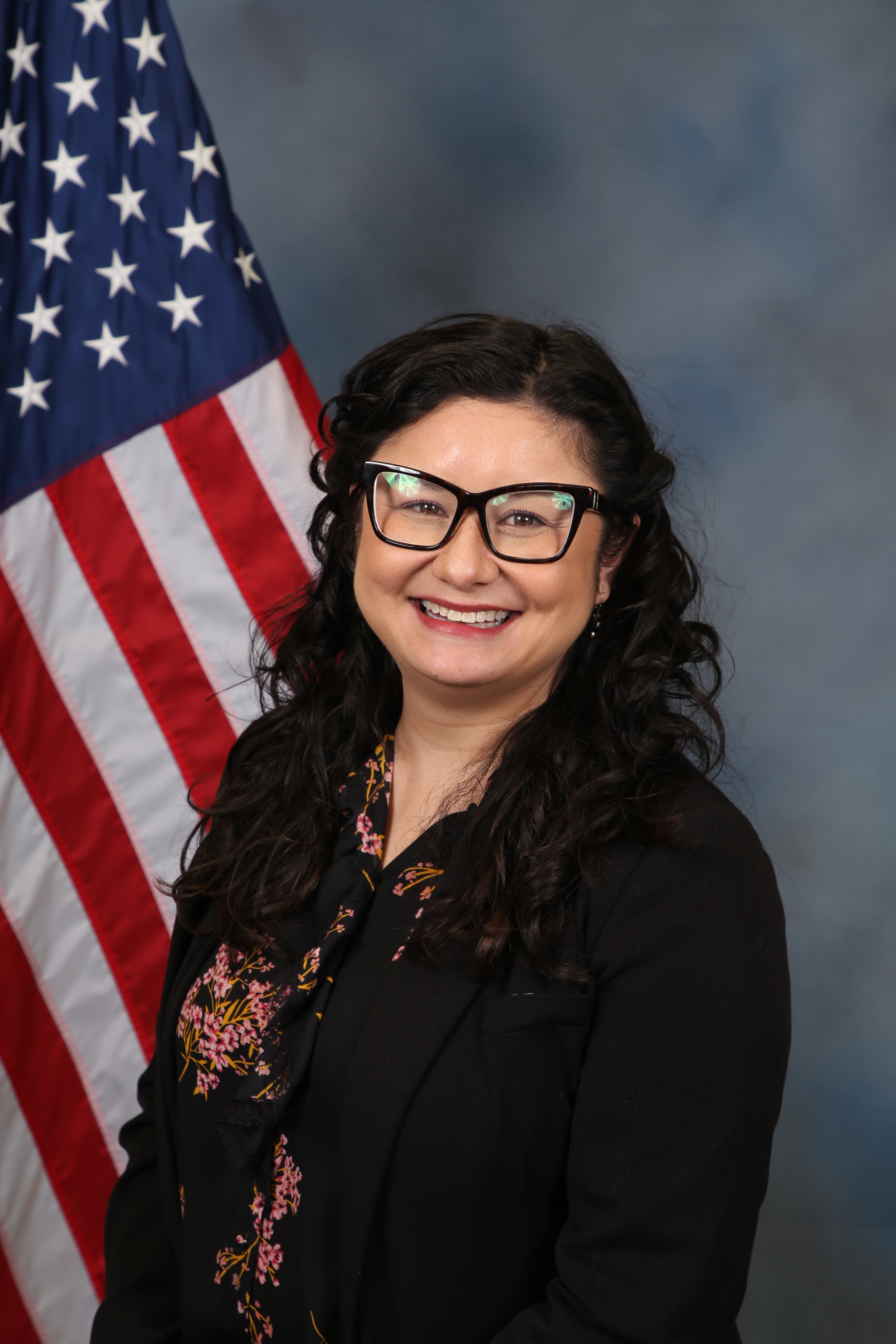 Photo of Natalie Weaver standing in front of the American flag.