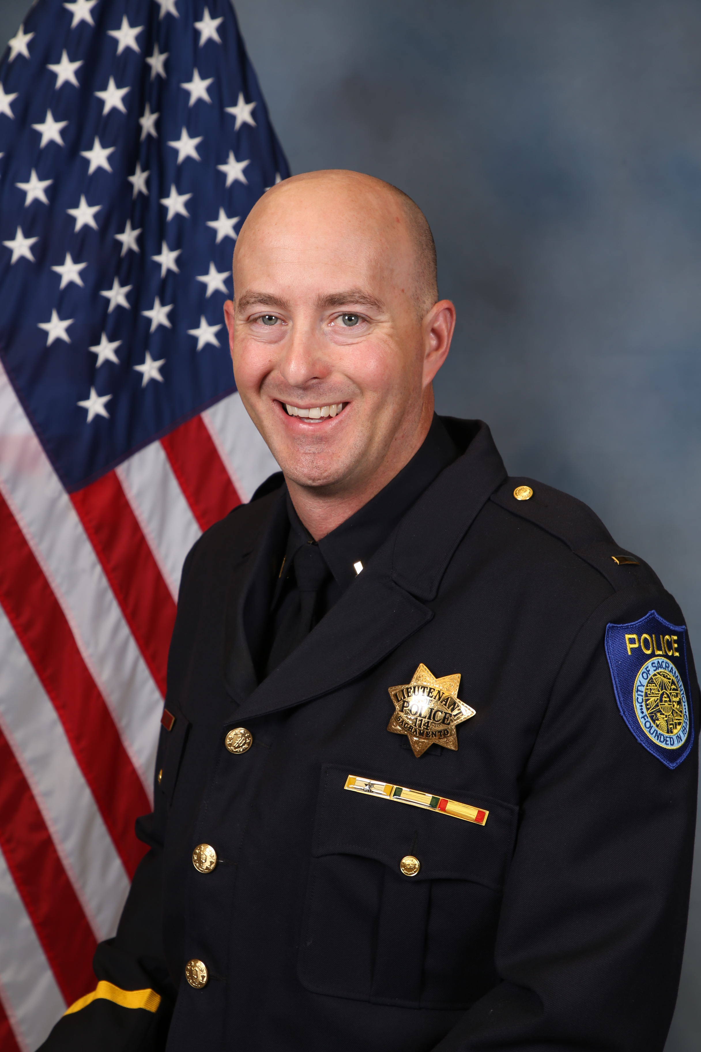 Photo of Robert Young in uniform standing in front of the American flag.