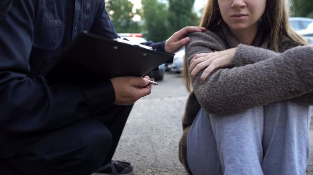 Officer trying to calm down victim, shocked girl crying