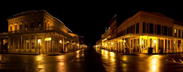 A photo of old Sacramento taken at night, the streets and old buildings are illuminated by the glow of yellow lighting. there are no people on the streets or sidewalks.