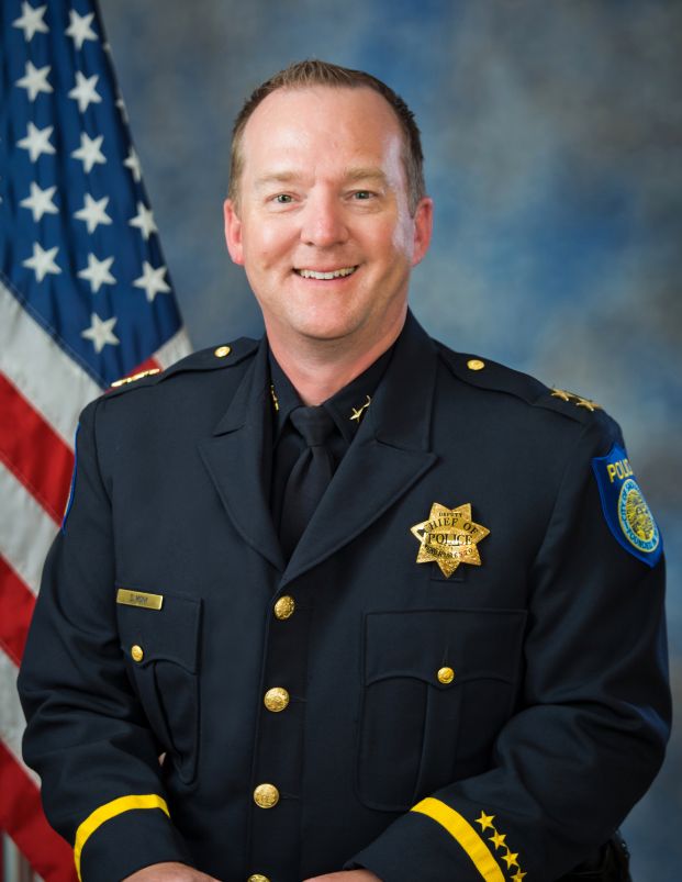 Photo of Captain Dan Monk in uniform in front of the American flag