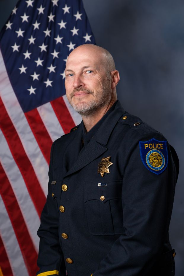 Photo of Lt. Bevins in Class "A" uniform with the American flag in the background.