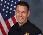 A portrait photo of the Sacramento Police Department Acting Lieutenant Darby Lannom, in full class-A uniform