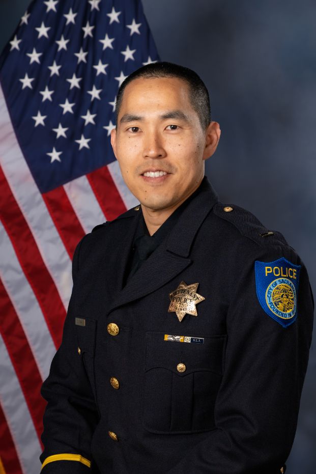 Photo of Lt. Sang Park in Class "A" uniform with the American flag in the background