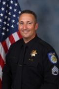 A portrait photo of the Sacramento Police Department Acting Lieutenant Michael Rinehart, in full class-A uniform