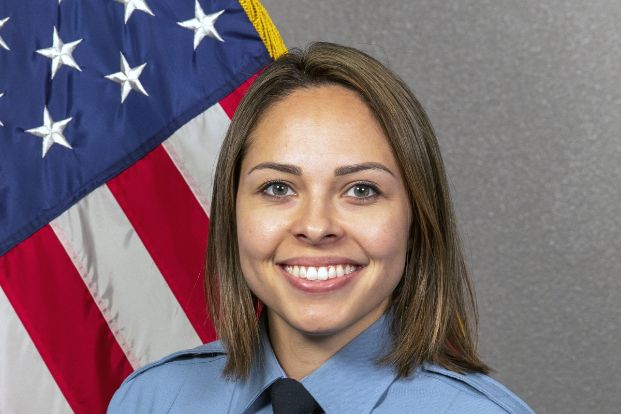 Photo of Stephanie Tovera in uniform with the American Flag in the background