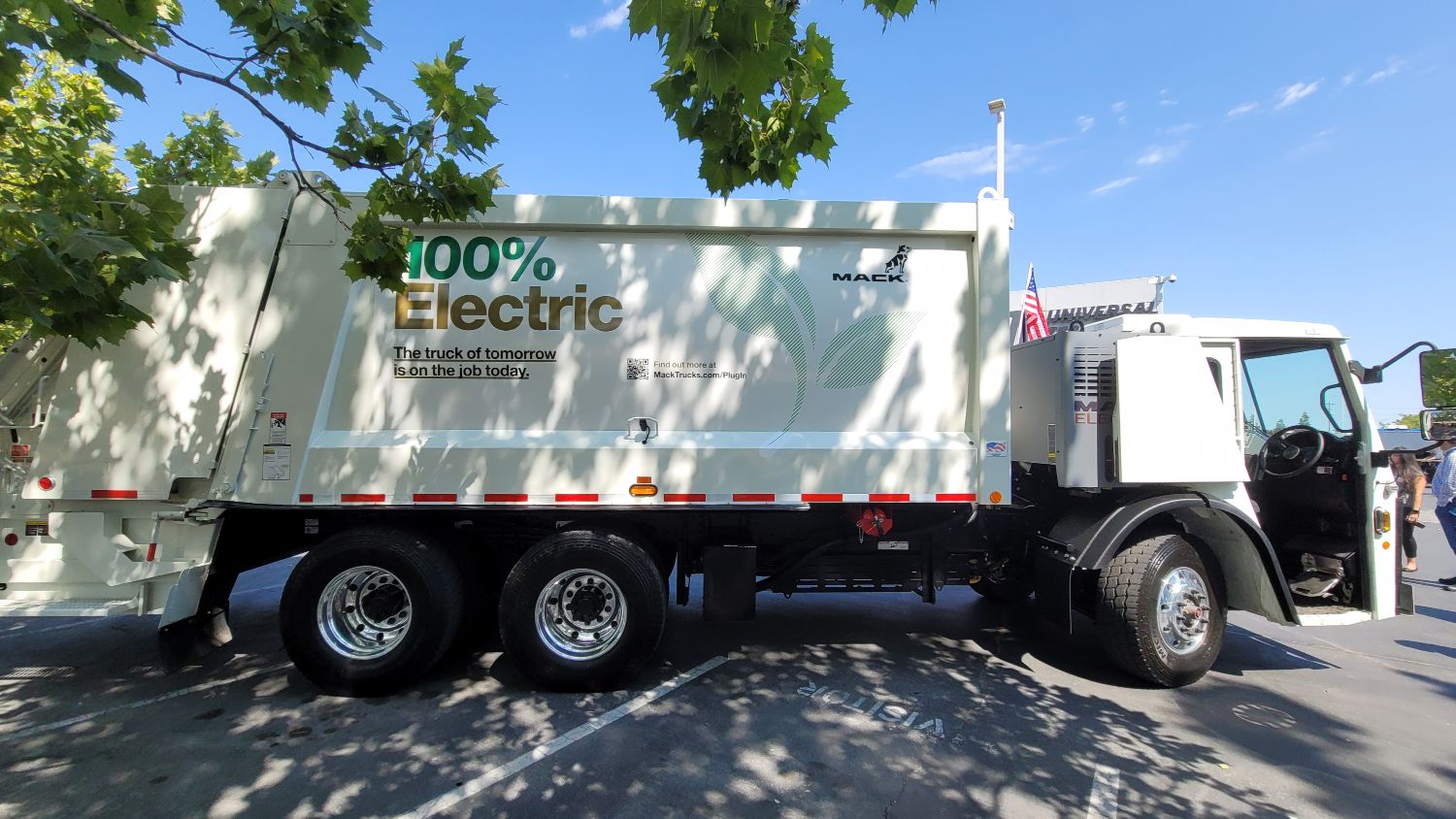 Mack Truck, 100% electric truck driving, surrounded by trees. 