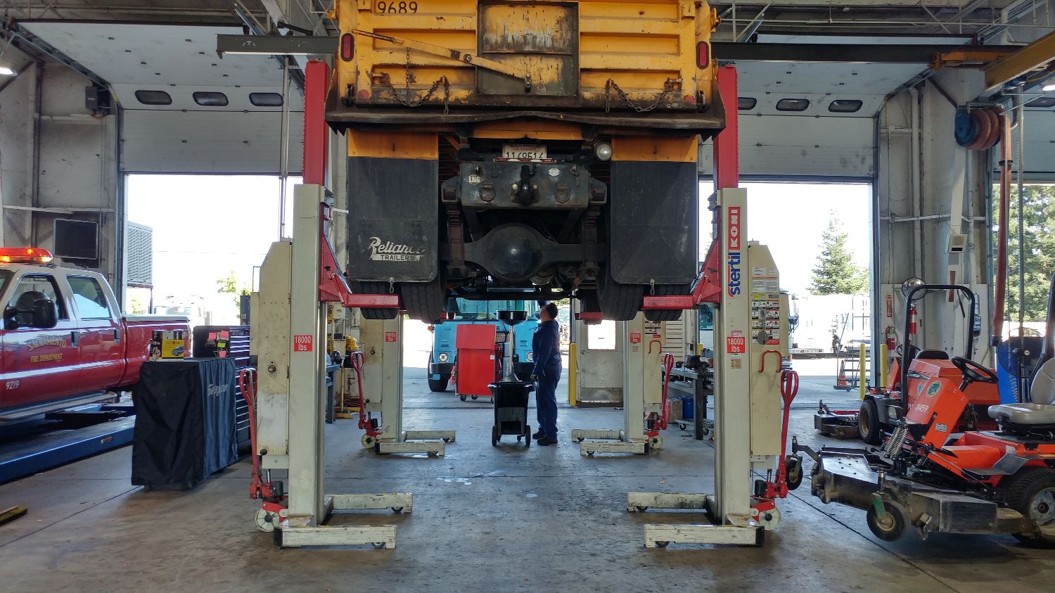 Fleet service technical vehicle trailer care, taken in a warehouse with other fleet vehicles present. 