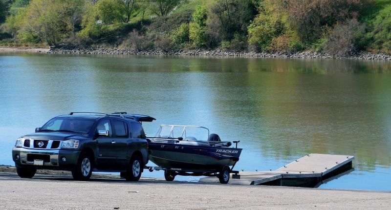 Image of a sports utility vehicle hitched to a boat trailer and delivering the boat to the launch ramp