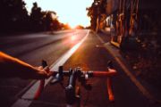 Image of POV of a bicyclist riding down a street during sunrise
