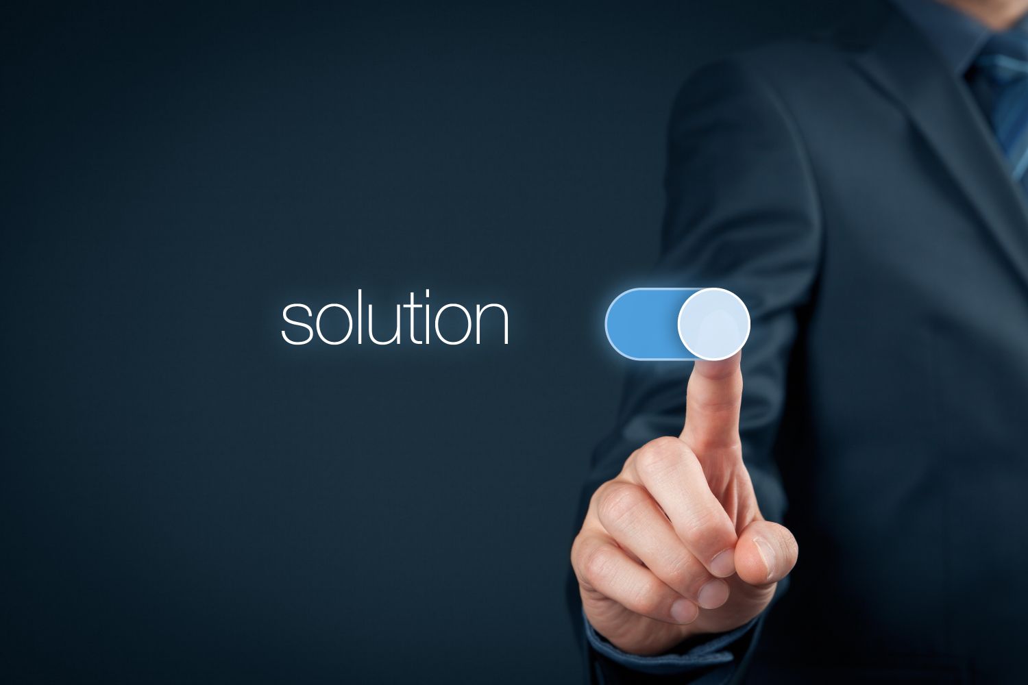 Image of a man in a suit pressing a toggle button next to the word, "solution"