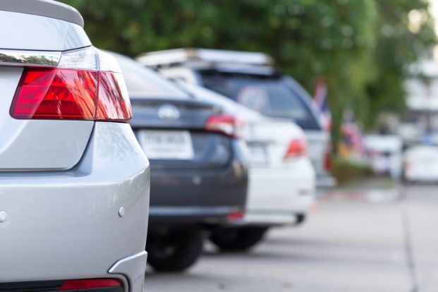 Image of bumpers of vehicles parked in angled parking stalls